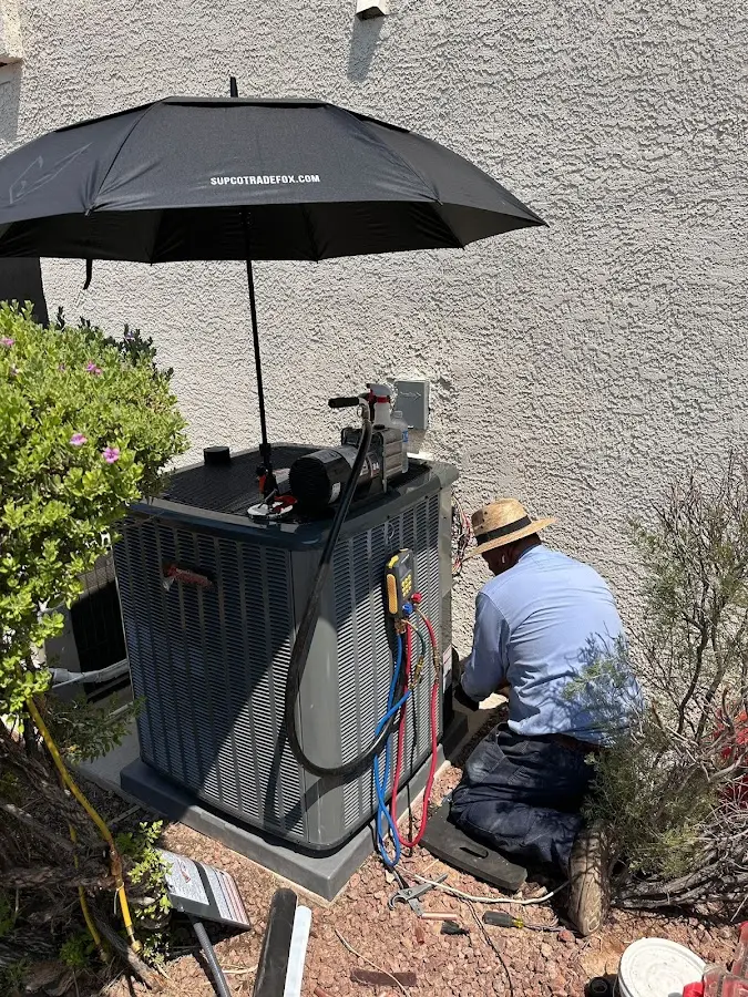 HVAC technician performing outdoor AC maintenance in Ahuimanu